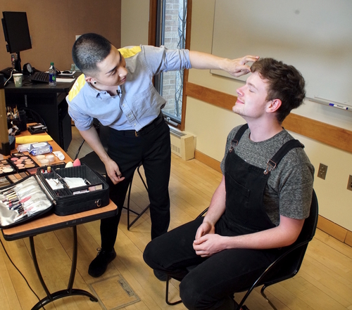 Kodo Nishimura applies make up to a student.