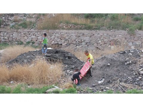 Some kids playing on a dump site. 